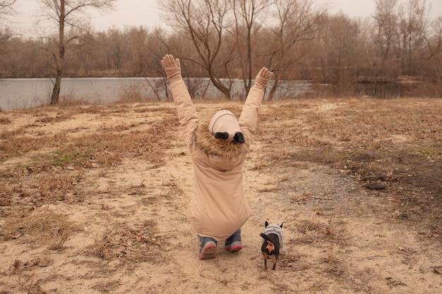 Teenage girl and chihuahua dog. School-age girl and her pet in the park in nature. Love for animals.