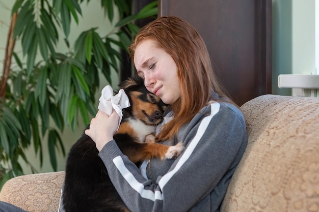 Teenage girl crying at home hugging a dog depression after breaking up with a guy