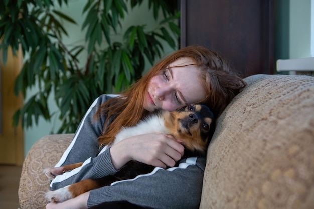 Teenage girl crying at home hugging a dog depression after breaking up with a guy