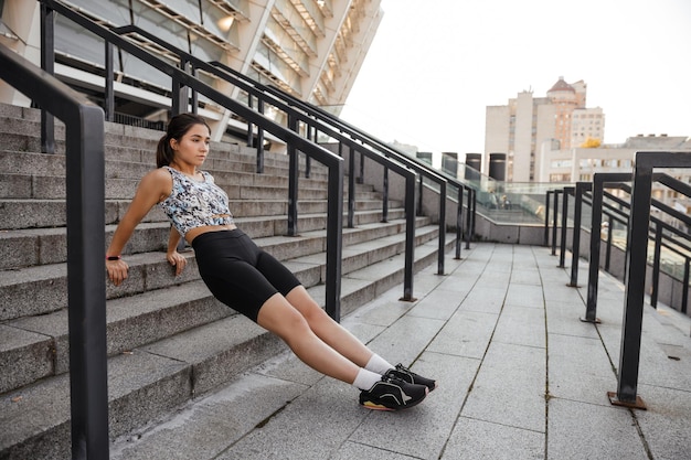 teenage girl doing sports warm up before workout outdoors of the city background