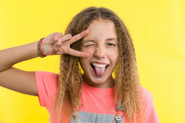 Teenage girl gesticulating, showing tongue, covering one eye