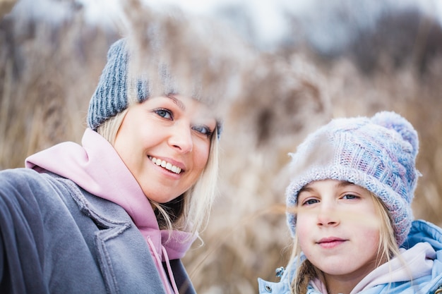 Teenage girl and her mother in the field in the winter