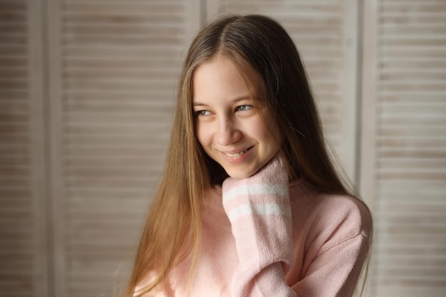 a teenage girl in jeans and a pink sweater with a different mood problems of a teenager