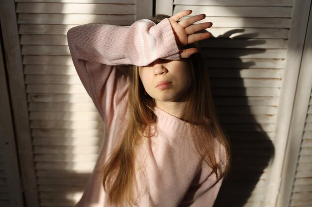 a teenage girl in jeans and a pink sweater with a different mood problems of a teenager