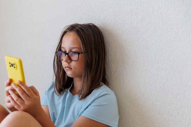 Teenage girl looks at the phone on a white background