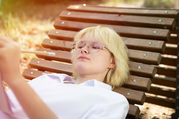 Teenage girl making notes or drawing in the blank paper booksunlight on background