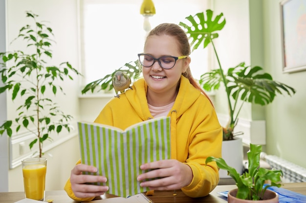 Teenage girl and pet green quaker parrot on the shoulder