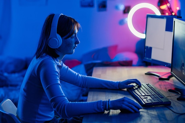 Teenage girl playing video game on computer