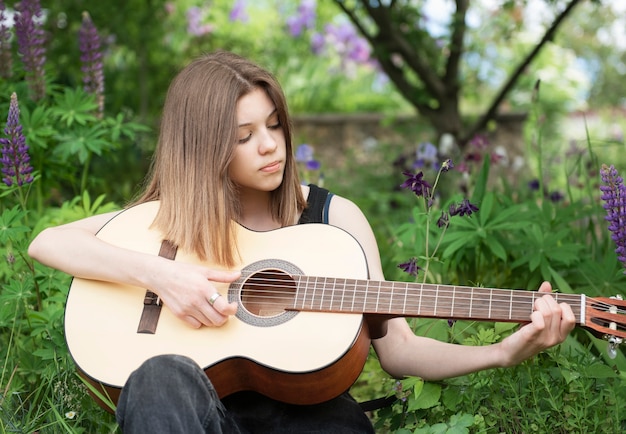 Teenage girl sitting with a guitar