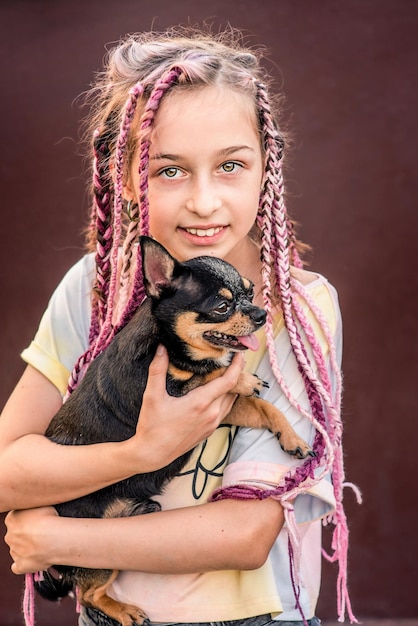 A teenage girl with a dog in her arms The little girl had a pet chihuahua