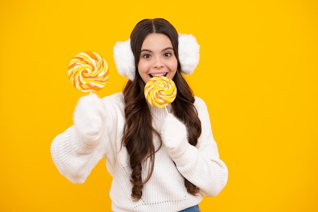 Teenage girl with lollipop child eating sugar lollipops kids sweets candy shop Excited teenager girl Happy face positive and smiling emotions of teenager girl