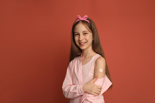 A teenage girl with a patch on her arm after vaccination The girl frowns Space for text vaccinat