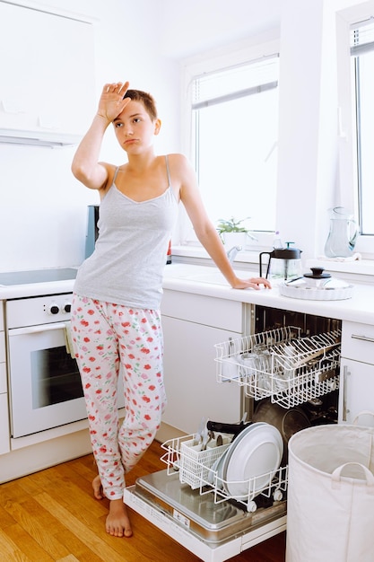 teenage girl with short hair, in home clothes, clutched head from fatigue from home routine.