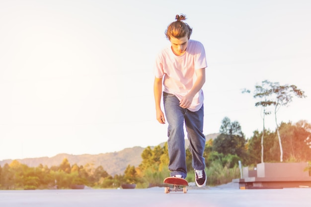 Teenage skater with pink tshirt and jeans slides on a skateboard in a skate park