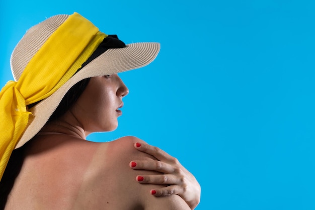 A teenager in a big beach hat holds a hand on a tanned shoulder