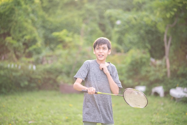 Teenager boy playing badminton outdoor outdoor park