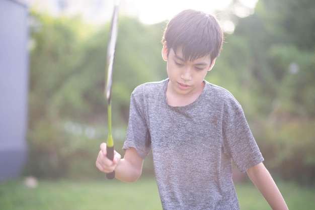 Teenager boy playing badminton outdoor outdoor park