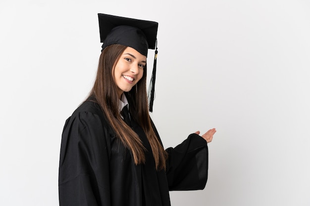 Teenager Brazilian university graduate over isolated white background extending hands to the side for inviting to come