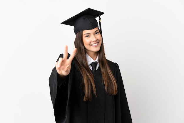 Teenager Brazilian university graduate over isolated white background smiling and showing victory sign