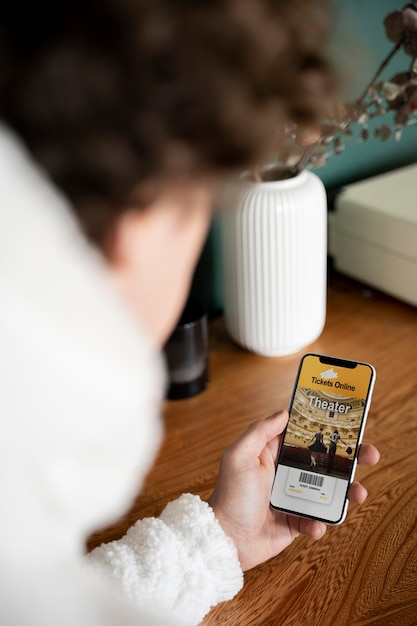 Teenager buying tickets using his smartphone while being at home