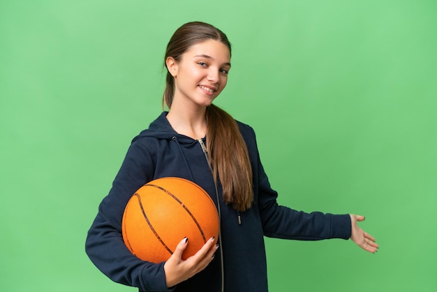 Teenager caucasian girl playing basketball over isolated background extending hands to the side for inviting to come