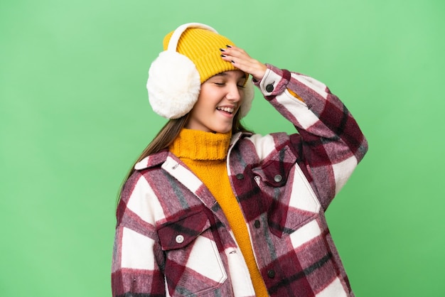 Teenager caucasian girl wearing winter muffs over isolated background has realized something and intending the solution