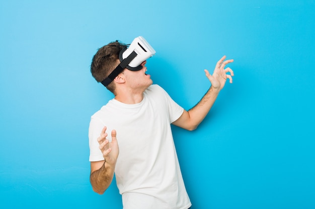 Teenager caucasian man using a virtual reality glasses