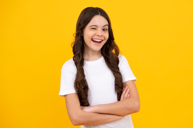 Teenager child girl close one eye winks and smiling Human facial emotions concept Funny winking face gesture Happy teenager positive and smiling emotions of teen girl