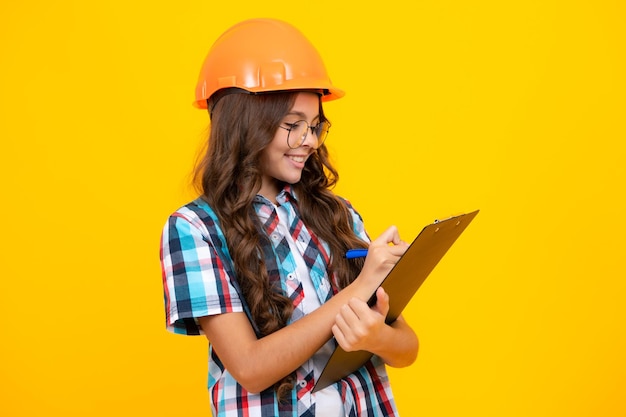 Teenager child painter in helmet with clipboard Child in hard hat Kid engineer on construction site Renovation and repair