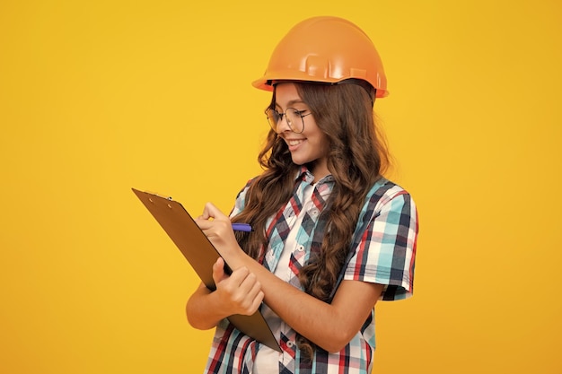 Teenager child painter in helmet with clipboard Child in hard hat Kid engineer on construction site Renovation and repair