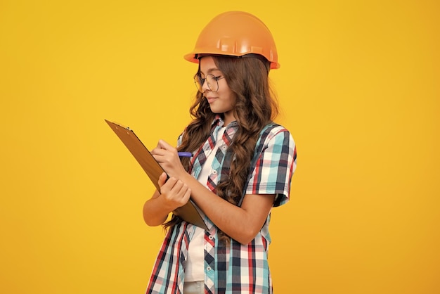 Teenager child painter in helmet with clipboard Child in hard hat Kid engineer on construction site Renovation and repair