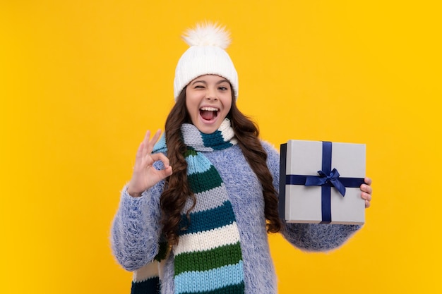 Teenager child in winter wear holding gift boxes celebrating happy New Year or Christmas Winter kids holiday Excited face cheerful emotions of teenager girl