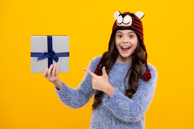 Teenager child in winter wear holding gift boxes celebrating happy New Year or Christmas Winter kids holiday Happy teenager positive and smiling emotions of teen girl