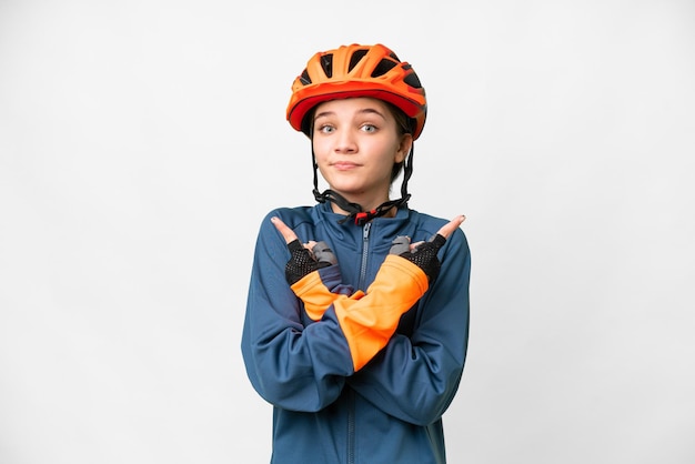 Teenager cyclist girl over isolated white background pointing to the laterals having doubts