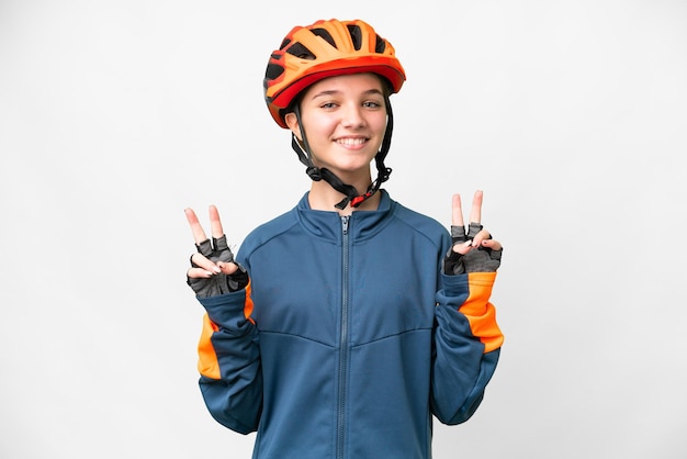 Teenager cyclist girl over isolated white background showing victory sign with both hands