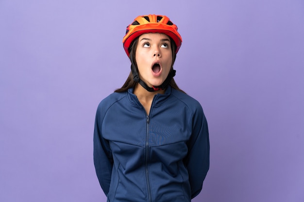 Teenager cyclist girl looking up and with surprised expression