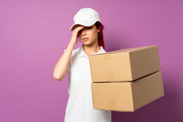 Teenager delivery girl isolated on purple background with headache