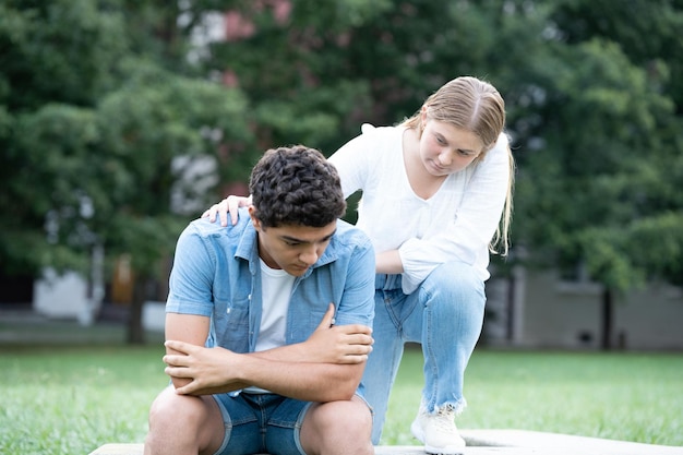 Teenager girl consoling sad hispanic boy