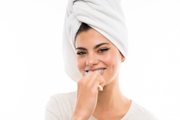 Teenager girl over isolated white wall brushing her teeths