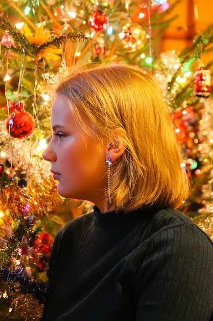 Teenager girl near the decorated Christmas tree