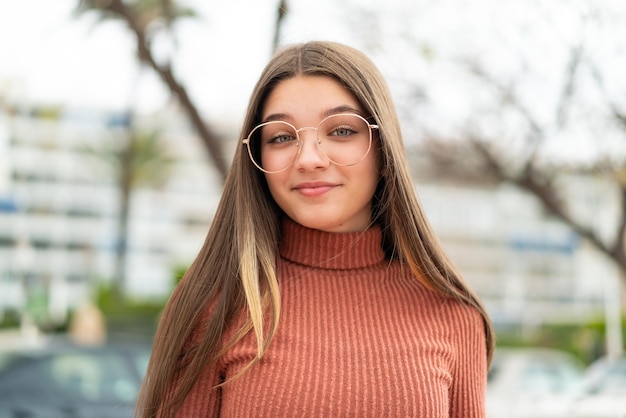 Teenager girl at outdoors smiling