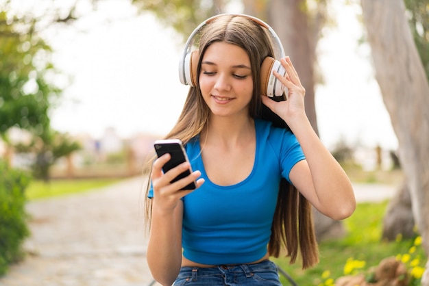 Teenager girl at outdoors using mobile phone