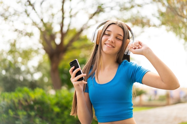 Teenager girl at outdoors using mobile phone