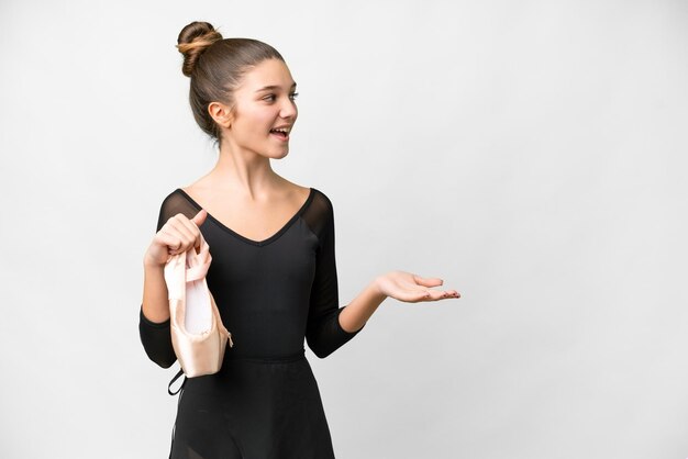 Teenager girl practicing ballet over isolated white background with surprise expression while looking side