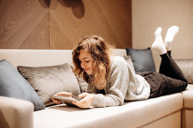 Teenager girl reading book on the couch at home