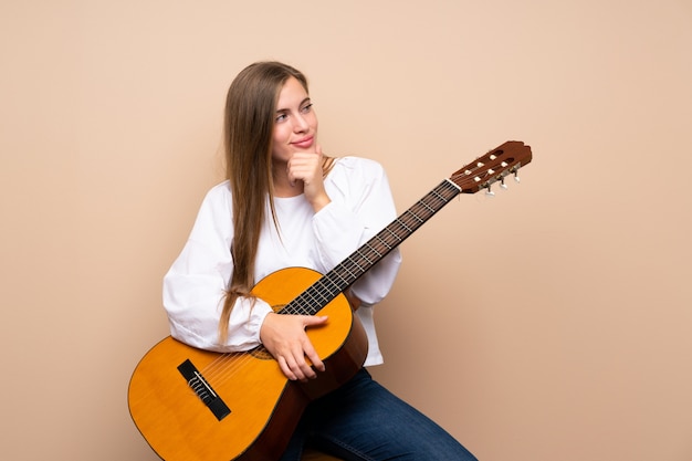 Teenager girl with guitar looking side