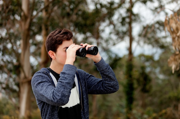 Teenager guy looking with binoculars 