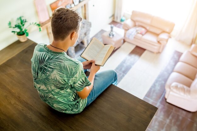 The teenager is reading a book sitting on the second floor of the house top view of the room selecti