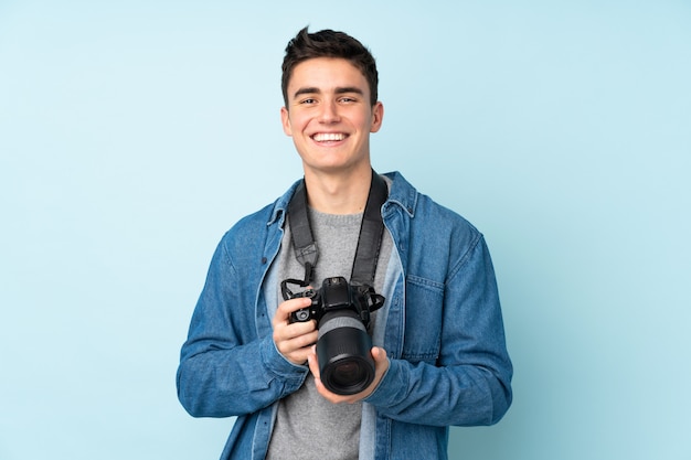 Teenager photographer man isolated on blue