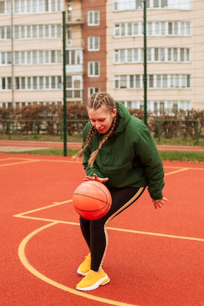 Teenager playing basketball outdoors